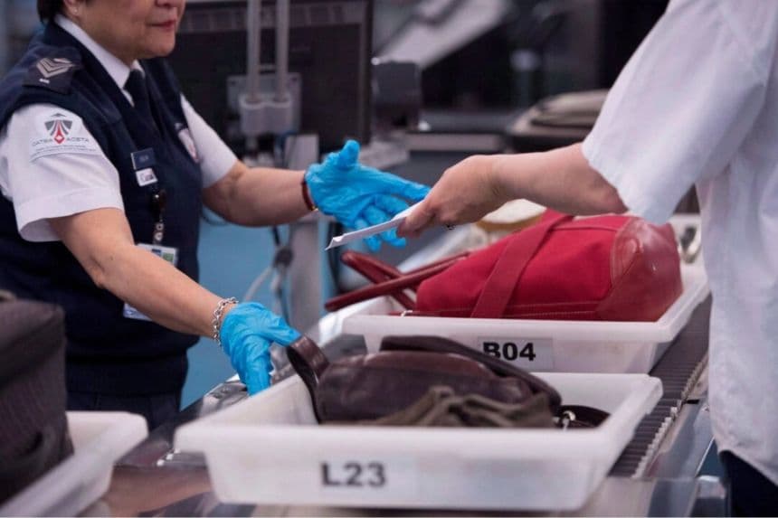Foto de archivo de un empleado realizando controles de seguridad a pasajeros y su equipaje de mano en el Aeropuerto Internacional de Vancouver, en Richmond, Columbia Británica. (Jonathan Hayward/The Canadian Press)