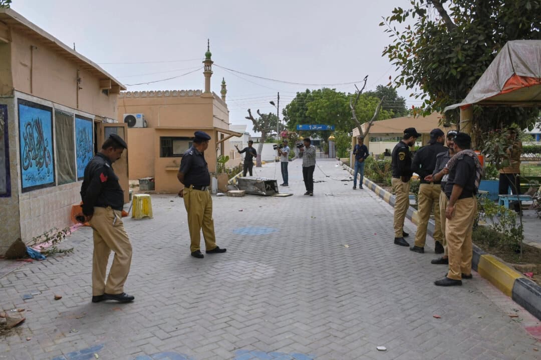 Oficiales de policía montan guardia mientras miembros de los medios de comunicación graban dentro de las instalaciones de la prisión del distrito de Malir, de donde escaparon más de 100 reclusos durante la noche, en Karachi, Pakistán, el 3 de junio de 2025. (Ali Raza/Foto de AP).