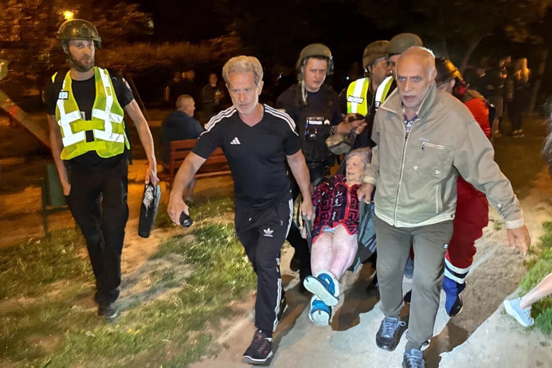 Policías y voluntarios evacúan a una persona de un edificio dañado por un ataque con drones rusos en Járkov, Ucrania, el 11 de junio de 2025. (Vitalii Hnidyi/Reuters)