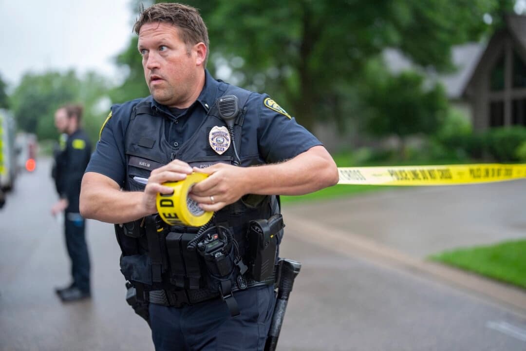 El teniente de policía Hjelm establece un perímetro con cinta policial cerca del lugar del tiroteo en Brooklyn Park, Minnesota, el 14 de junio de 2025. (Alex Kormann/Star Tribune vía AP)