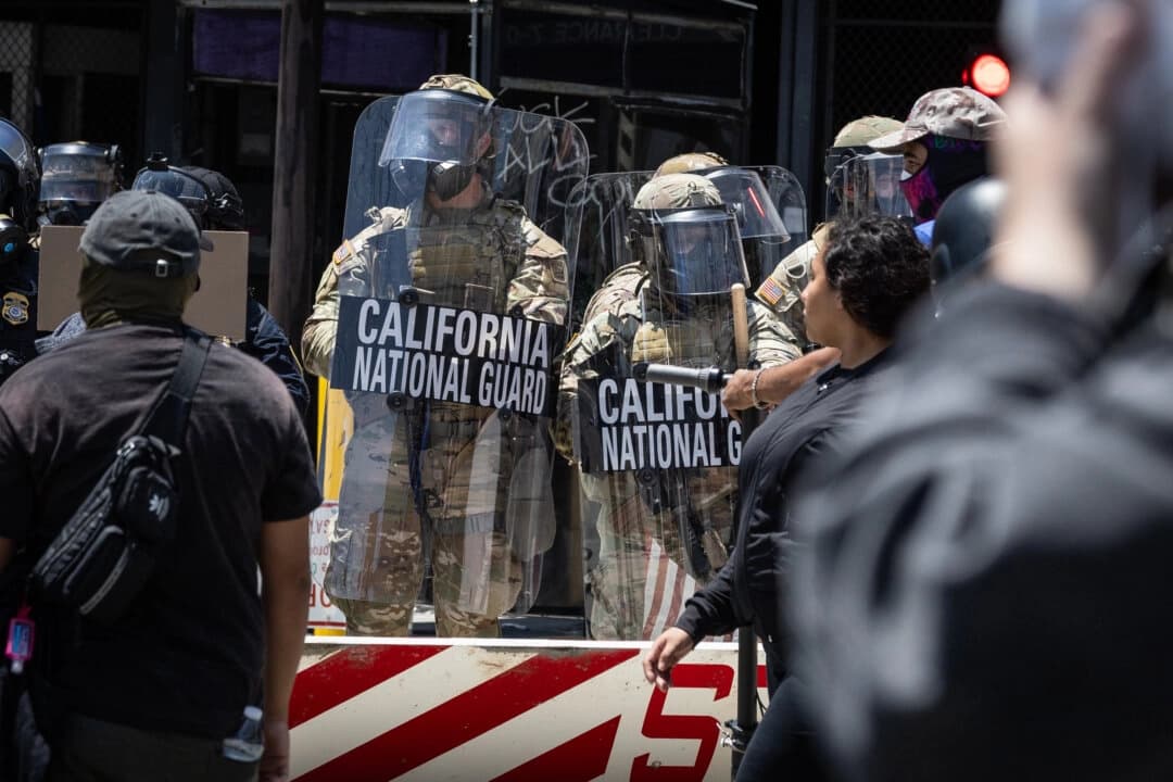 Manifestantes contra la inmigración se enfrentan a agentes federales y miembros de la Guardia Nacional de California en Los Ángeles, California, el 8 de junio de 2025. (John Fredricks/The Epoch Times).