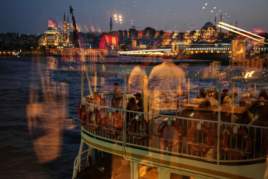 Los pasajeros, vistos a través de una ventana, suben a bordo de un ferry antes de zarpar desde la terminal de Karakoy, en Estambul, Turquía, el 13 de junio de 2025. (Francisco Seco/AP Photo).