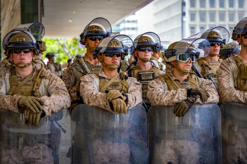Soldados del Cuerpo de Marines de los Estados Unidos (USMC) vigilan el Edificio Federal mientras cientos de manifestantes se reúnen en la calle durante la protesta nacional "No Kings" en Los Ángeles el 14 de junio de 2025. (Benjamin Hanson/Middle East Images vía AFP vía Getty Images).