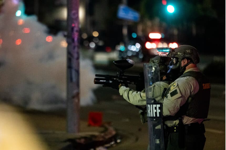 Las fuerzas del orden y los manifestantes se enfrentan durante una protesta tras las operaciones federales de inmigración, en el barrio de Compton, en Los Ángeles, California, en la madrugada del 8 de junio de 2025. (Etienne Laurent / AFP).