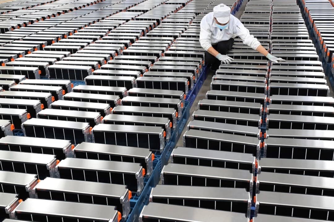 Un trabajador posa con baterías de coche en una fábrica de Xinwangda Electric Vehicle Battery Co., que fabrica baterías de litio para coches eléctricos y otros usos, en Nanjing, en la provincia oriental china de Jiangsu, el 12 de marzo de 2021. (STR/AFP a través de Getty Images)