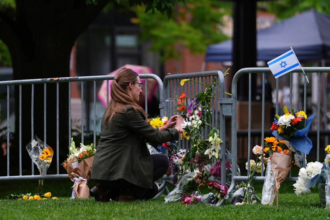 Una mujer coloca un ramo de flores en un memorial improvisado para las víctimas de un atentado frente al juzgado del condado de Boulder, en Boulder, Colorado, el 3 de junio de 2025. (David Zalubowski/AP Photo).
