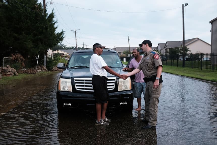 Los residentes hablan con un agente de policía en una calle inundada en Orange, mientras Texas avanza lentamente hacia la recuperación tras la devastación causada por el huracán Harvey en Orange, Texas, el 6 de septiembre de 2017. (Spencer Platt/Getty Images).