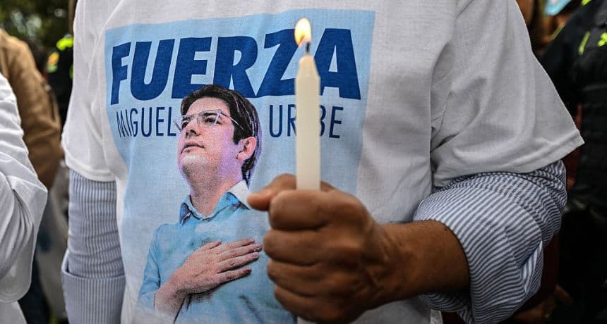 Un hombre con una camiseta con la imagen del candidato presidencial colombiano Miguel Uribe sostiene una vela durante una misa por la salud de Uribe en Bogotá, el 21 de junio de 2025. (LUIS ACOSTA/AFP vía Getty Images)