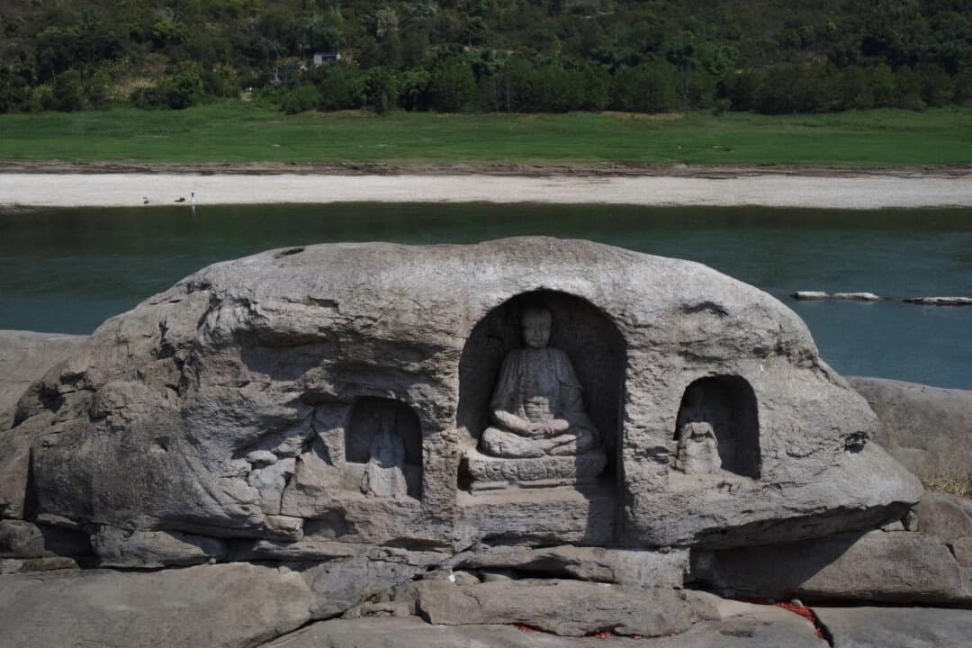 Una estatua de Buda que estuvo sumergida se encuentra ahora en la cima del arrecife de la isla Foyeliang, en el río Yangtsé, que apareció tras la bajada del nivel del agua debido a una sequía regional en Chongqing, China, el 20 de agosto de 2022. (Thomas Peter/Reuters)