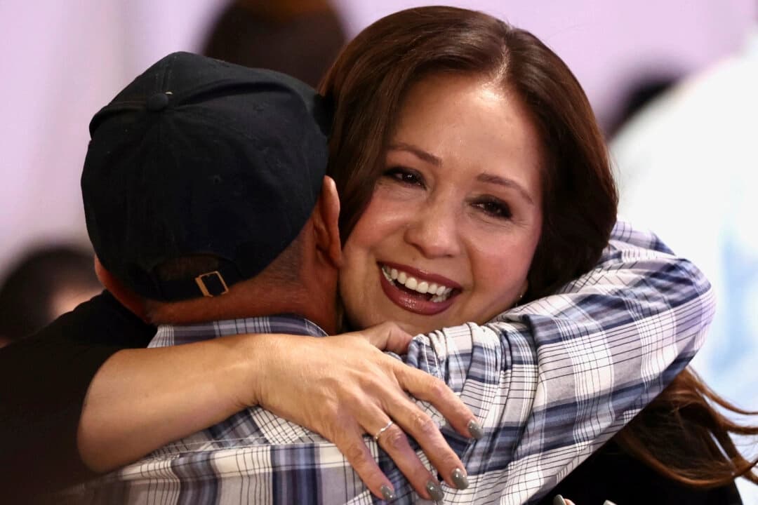 Adelita Grijalva, que aspira a la candidatura demócrata en unas elecciones primarias especiales para sustituir a su difunto padre, Raúl Grijalva, en el 7.º distrito electoral de Arizona, abraza a un simpatizante en una reunión celebrada la noche de las elecciones, en Tucson, Arizona, el 15 de julio de 2025. (Kelly Presnell/Arizona Daily Star vía AP).