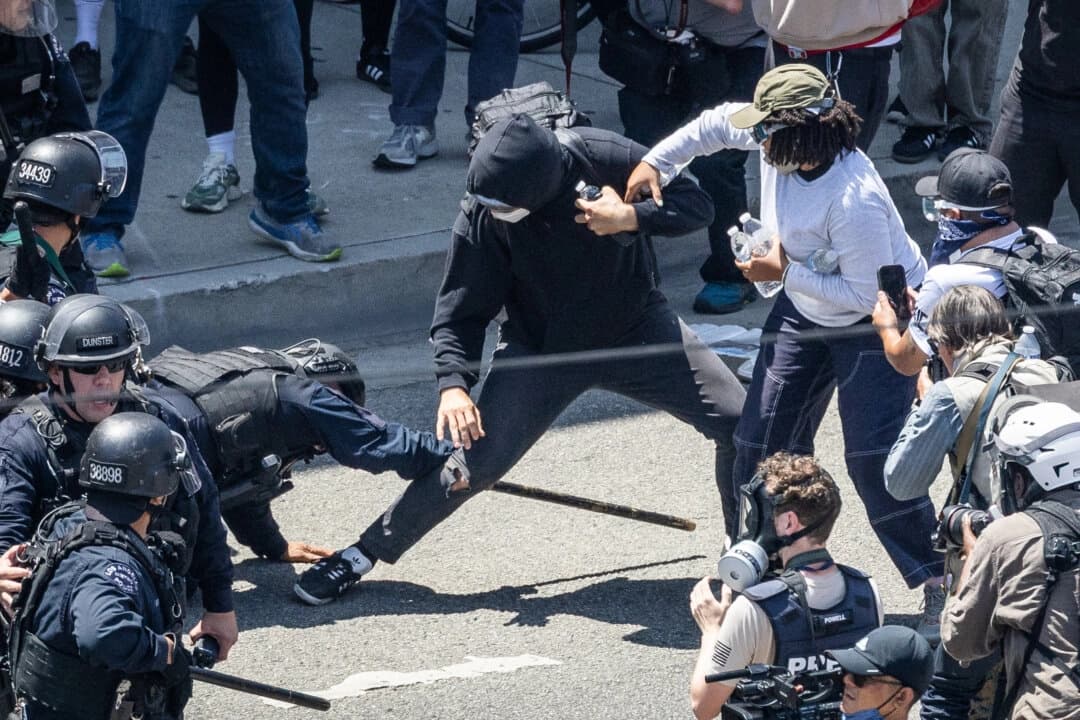 Oficiales de la policía de Los Ángeles se enfrentan a manifestantes contra la ley de inmigración en Los Ángeles el 8 de junio de 2025. (John Fredricks/The Epoch Times).