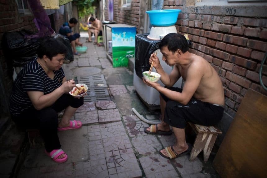 Personas cenan en las calles de un pueblo de migrantes en las afueras de Beijing, el 17 de agosto de 2017. (Nicolas Asfouri/AFP/Getty Images)