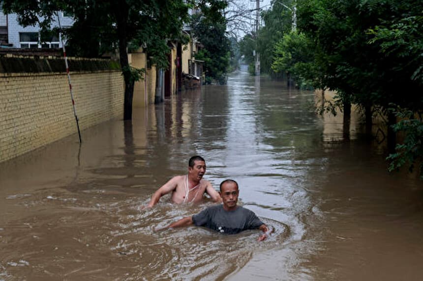 Los residentes locales luchan contra las corrientes rápidas y profundas mientras se dirigen hacia los equipos de rescate en una embarcación en una zona inundada cerca de Zhuozhou, provincia de Hebei, al sur de Beijing, el 3 de agosto de 2023. (Kevin Frayer/Getty Images).