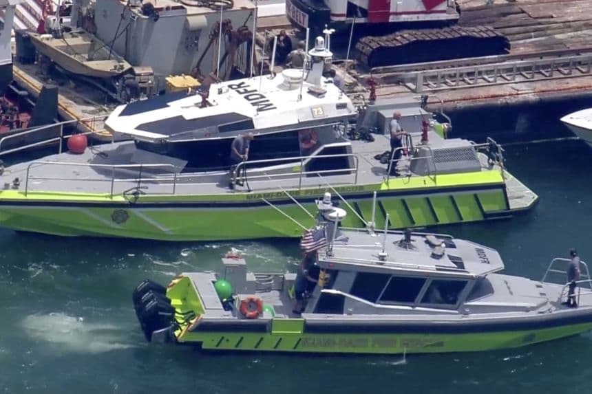 Esta imagen tomada de un video proporcionado por WSVN-TV muestra al Departamento de Bomberos de Miami-Dade y otros en botes alrededor de lo que parece ser una barcaza involucrada en un accidente con un grupo de niños y un adulto en un velero durante un campamento de vela, el lunes 28 de julio de 2025, en Miami. (WSVN-TV vía AP)