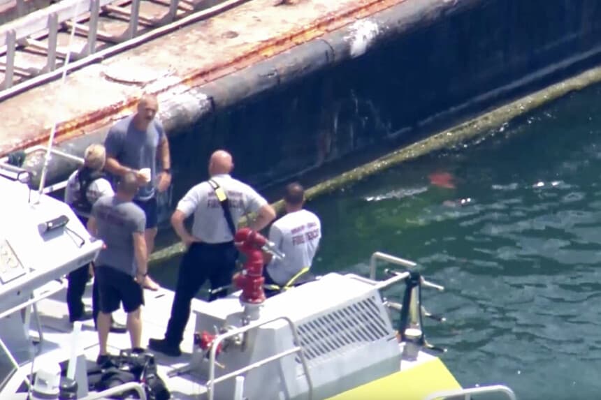 La imagen tomada de un video proporcionado por WSVN-TV muestra al Cuerpo de Bomberos de Miami-Dade y otros servicios de emergencia en una embarcación alrededor de lo que parece ser una barcaza involucrada en un accidente con un grupo de niños y un adulto en un velero durante un campamento de vela, el lunes 28 de julio de 2025, en Miami. (WSVN-TV vía AP).