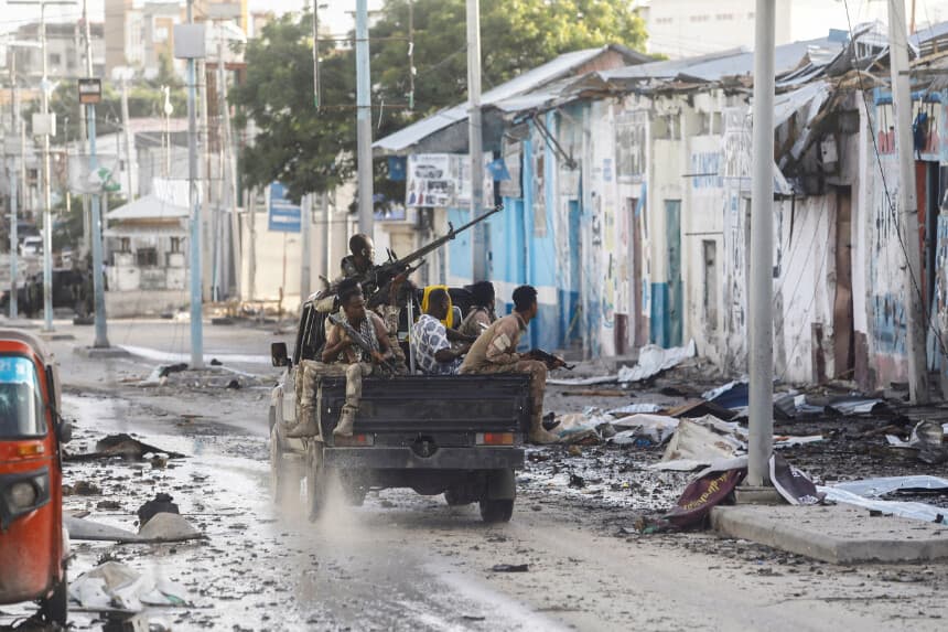 Oficiales de seguridad somalíes pasan frente a una sección del Hotel Hayat, escenario de un atentado terrorista perpetrado por el grupo Al-Shabaab en Mogadiscio, Somalia, el 20 de agosto de 2022. (Feisal Omar/Reuters).