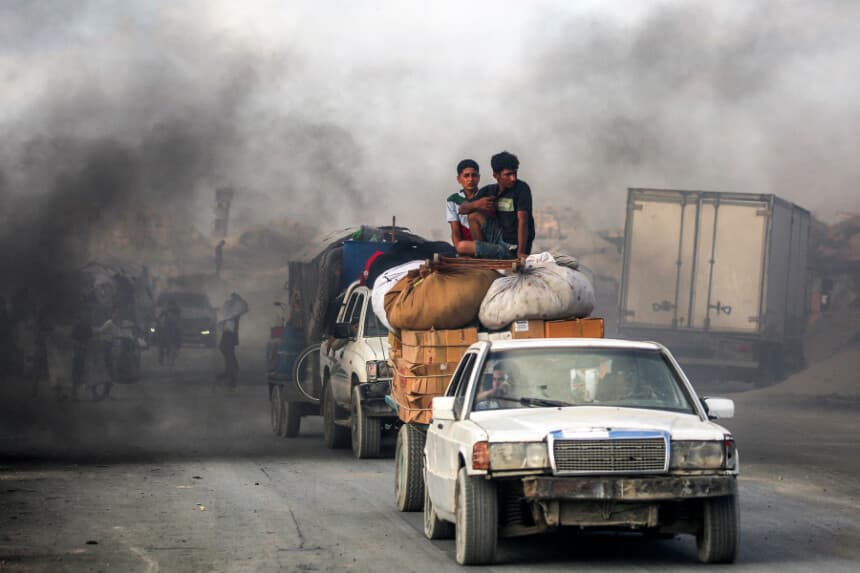 Jóvenes viajan sobre paquetes y muebles en un carro remolcado por otro vehículo mientras la gente evacúa hacia el sur desde la ciudad de Gaza el 2 de septiembre de 2025. (EYAD BABA/AFP a través de Getty Images).