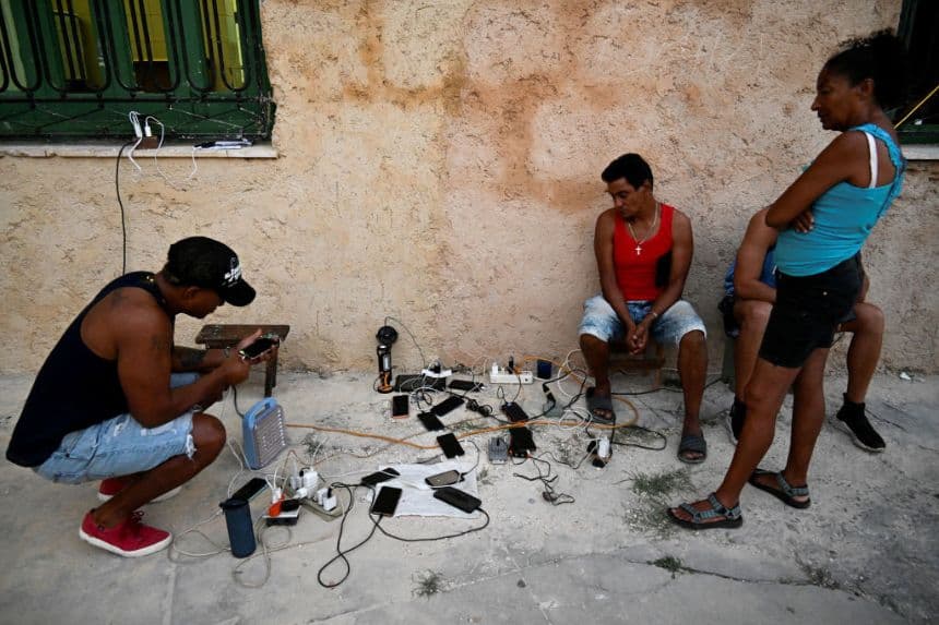 Los cubanos cargan sus teléfonos móviles durante un apagón nacional causado por un fallo en la red eléctrica en La Habana (Foto de YAMIL LAGE/AFP a través de Getty Images)