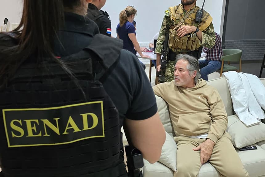 Fotografía cedida por la Secretaría Nacional Antidrogas que muestra a integrantes de las Fuerzas Armadas custodiando al presunto líder del grupo criminal La Barredora, Hernán Bermúdez Requena, en Mariano Roque Alonso, Paraguay. (SEFE/ Secretaría Nacional Antidrogas de Paraguay)