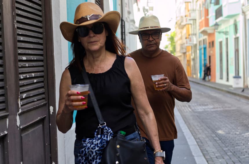 Fotografía de archivo que muestra a una pareja mientras camina con vasos de plástico en San Juan, Puerto Rico. (EFE/ Thais Llorca)