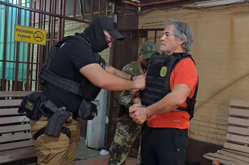 Fotografía cedida por la Secretaría Nacional Antidrogas de Paraguay que muestra el traslado del presunto líder del grupo criminal La Barredora, Hernán Bermúdez Requena (d), hacia el Aeropuerto Internacional Silvio Pettirossi en Asunción, Paraguay. (EFE/ Secretaría Nacional Antidrogas De Paraguay)