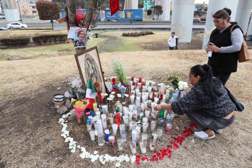 Personas encienden velas en un altar en la zona donde ocurrió la explosión de un camión de gas en Ciudad de México (EFE/ Mario Guzmán)