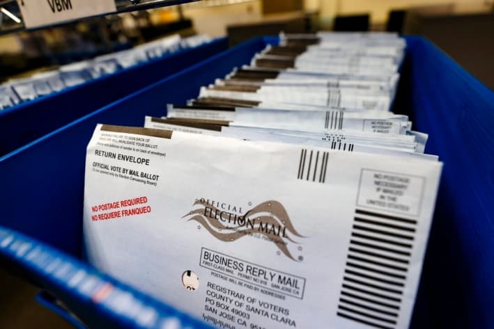 Las papeletas de voto por correo se colocan en bandejas antes de ser clasificadas en la oficina del registro de votantes del condado de Santa Clara, en San José, California, el 13 de octubre de 2020. (Justin Sullivan/Getty Images)