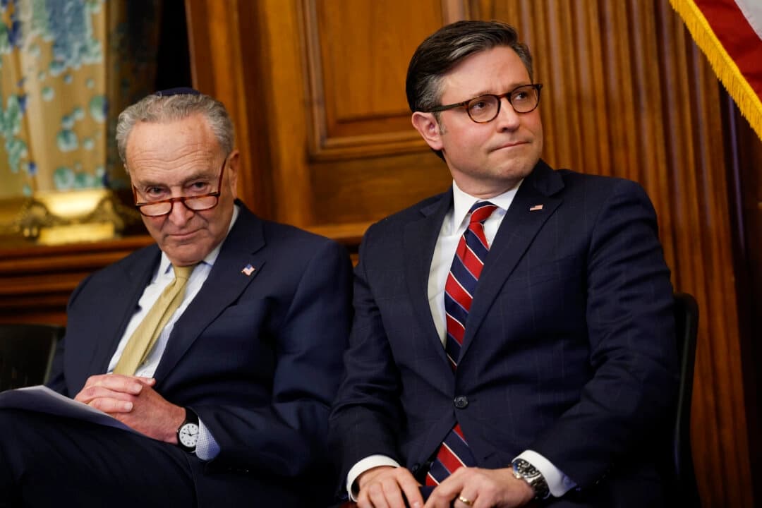 El líder de la mayoría del Senado, Chuck Schumer (D-N.Y.), y el presidente de la Cámara de Representantes, Mike Johnson (R-La.), escuchan durante los discursos en la ceremonia de encendido de la menorá en el Capitolio de los Estados Unidos en Washington el 12 de diciembre de 2023. (Anna Moneymaker/Getty Images)