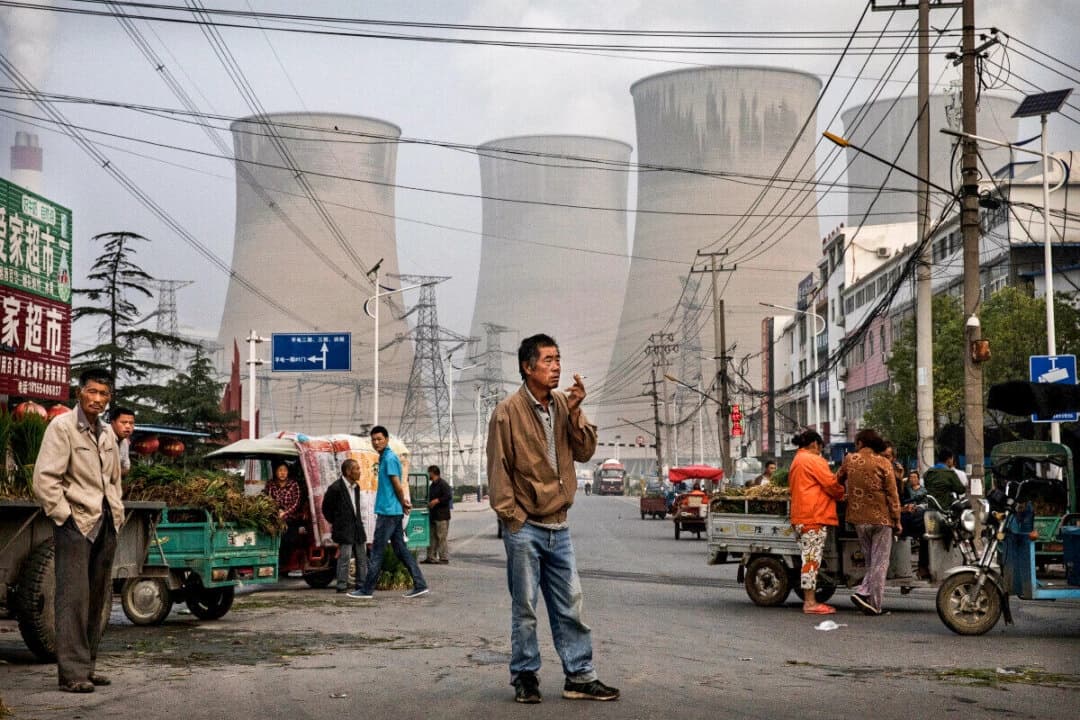 Vendedores ambulantes y clientes chinos se reúnen en un mercado local frente a una central eléctrica de carbón de propiedad estatal en la provincia de Anhui, China, el 14 de junio de 2017. (Kevin Frayer/Getty Images)