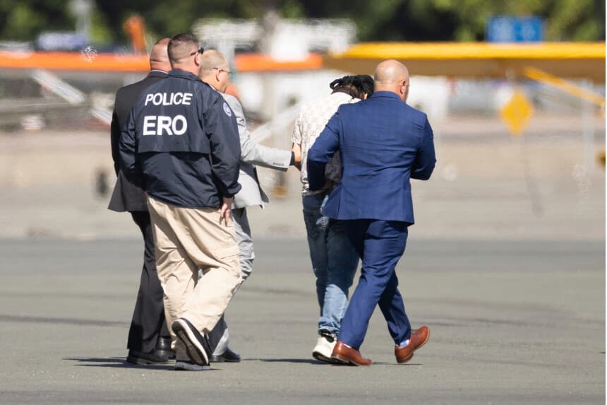 Harjinder Singh es escoltado hasta un avión por el vicegobernador de Florida, Jay Collins, y las fuerzas del orden en Stockton, California, el 21 de agosto de 2025. (Benjamin Fanjoy/AP).