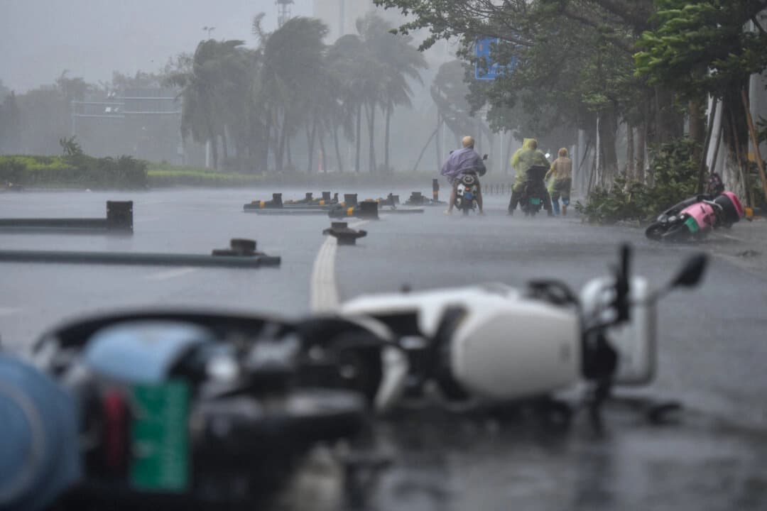 La gente circula en patinetes eléctricos en medio de los fuertes vientos y las intensas lluvias provocadas por el tifón Matmo, en Haikou, provincia de Hainan, China, el 5 de octubre de 2025. (cnsphoto vía Reuters)