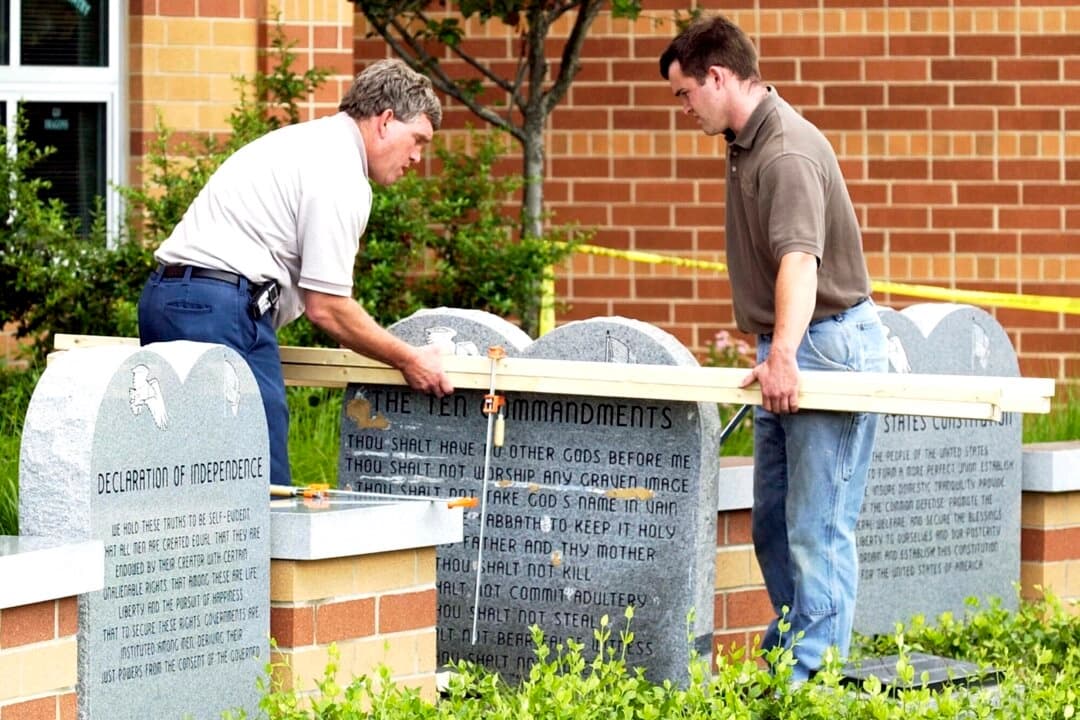 Unos trabajadores retiran un monumento con los Diez Mandamientos situado frente al instituto West Union High School, en West Union, Ohio, el 9 de junio de 2003. (Al Behrman/AP Photo).