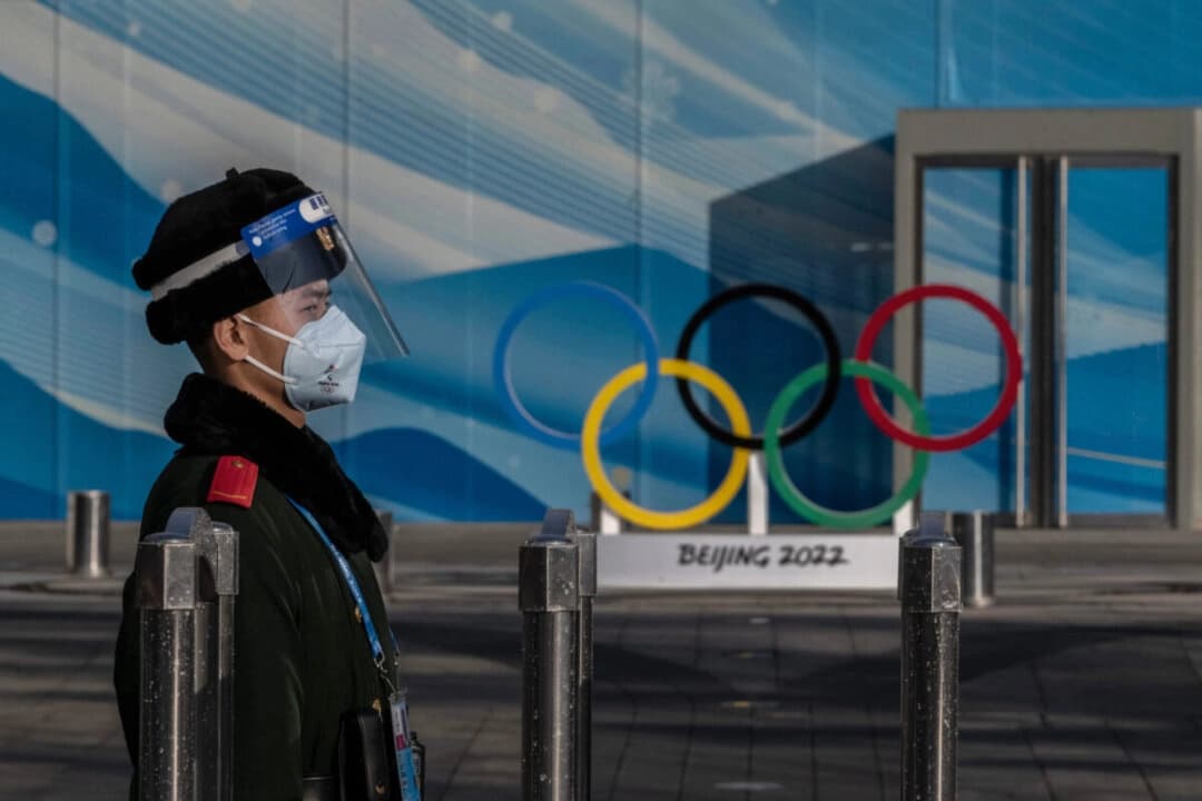 Un agente de policía monta guardia dentro del circuito cerrado de seguridad para los Juegos Olímpicos de Invierno de Beijing 2022, cerca del centro principal de medios de comunicación en el Parque Olímpico de Beijing, el 29 de enero de 2022. (Kevin Frayer/Getty Images)