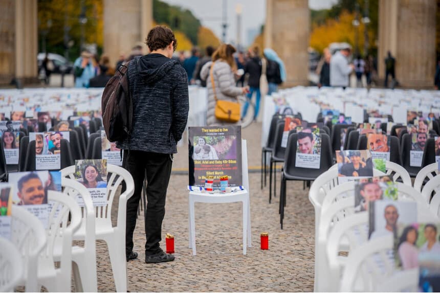 La gente visita las filas de sillas vacías con fotos de víctimas y rehenes israelíes expuestas durante una vigilia conmemorativa frente a la Puerta de Brandeburgo en Berlín el 7 de octubre de 2025. La instalación, con más de 1000 sillas, fue organizada por la Unión de Estudiantes Judíos de Alemania para conmemorar a las víctimas del ataque terrorista perpetrado por Hamás contra Israel el 7 de octubre de 2023. (Stefan Frank/Middle East Images/AFP a través de Getty Images).