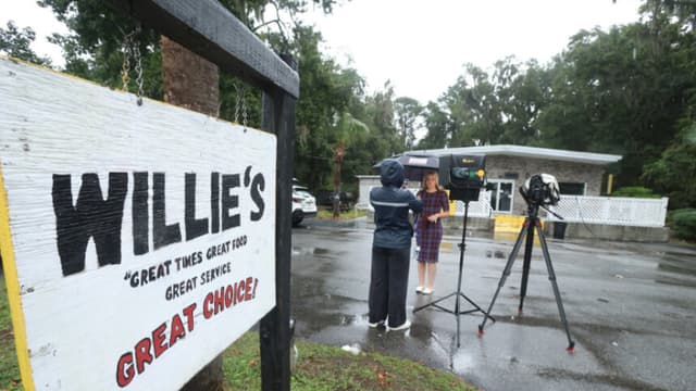 Un periodista trabaja frente al Willie's Bar and Grill en St Helena Island, Carolina del Sur, tras un tiroteo ocurrido la madrugada del domingo 12 de octubre de 2025. (AP Photo/Lewis M. Levine).