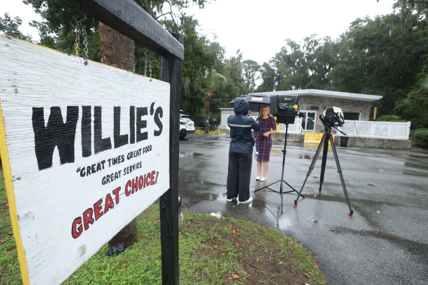 Un periodista trabaja frente al Willie's Bar and Grill en St Helena Island, Carolina del Sur, tras un tiroteo ocurrido la madrugada del domingo 12 de octubre de 2025. (AP Photo/Lewis M. Levine).