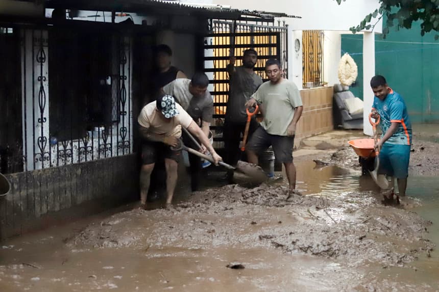 Habitantes de las zonas afectadas por las fuertes lluvias retiran lodo de sus viviendas el domingo 12 de octubre, en Huauchinango, México. (EFE/ Hilda Ríos)