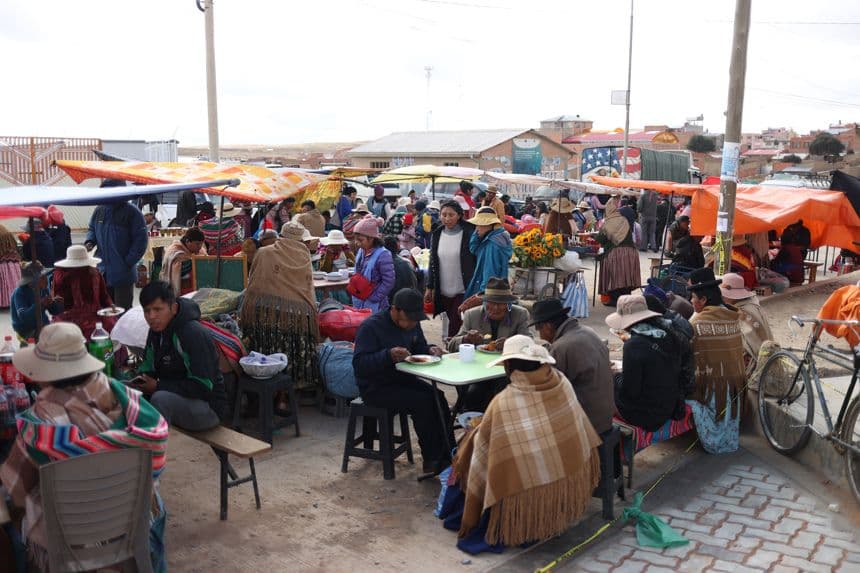 Fotografía de personas comiendo este domingo, durante la segunda vuelta electoral en la comunidad de Laja, Bolivia. (EFE/ Luis Gandarillas)
