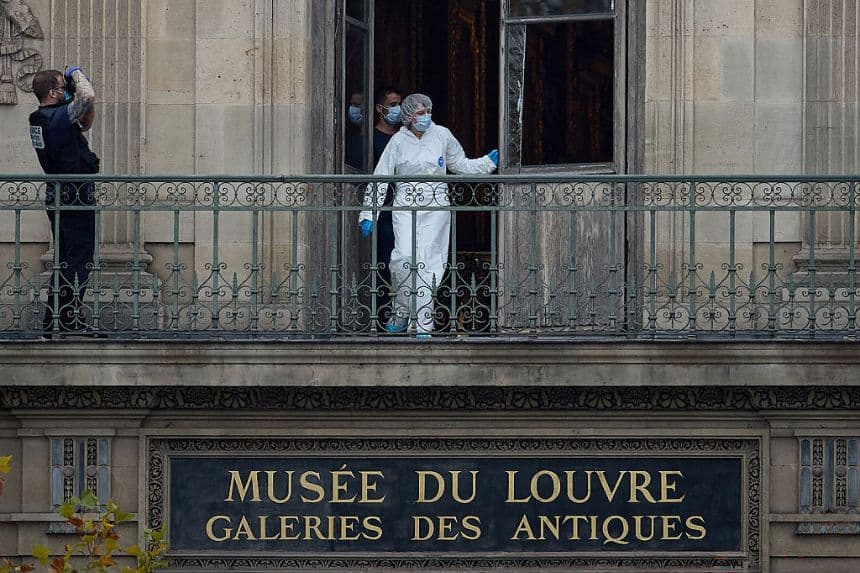 Un agente forense francés examina la ventana rota del balcón de la escena del crimen en el Louvre de París el 19 de octubre de 2025. (Kiran Ridley/Getty Images)