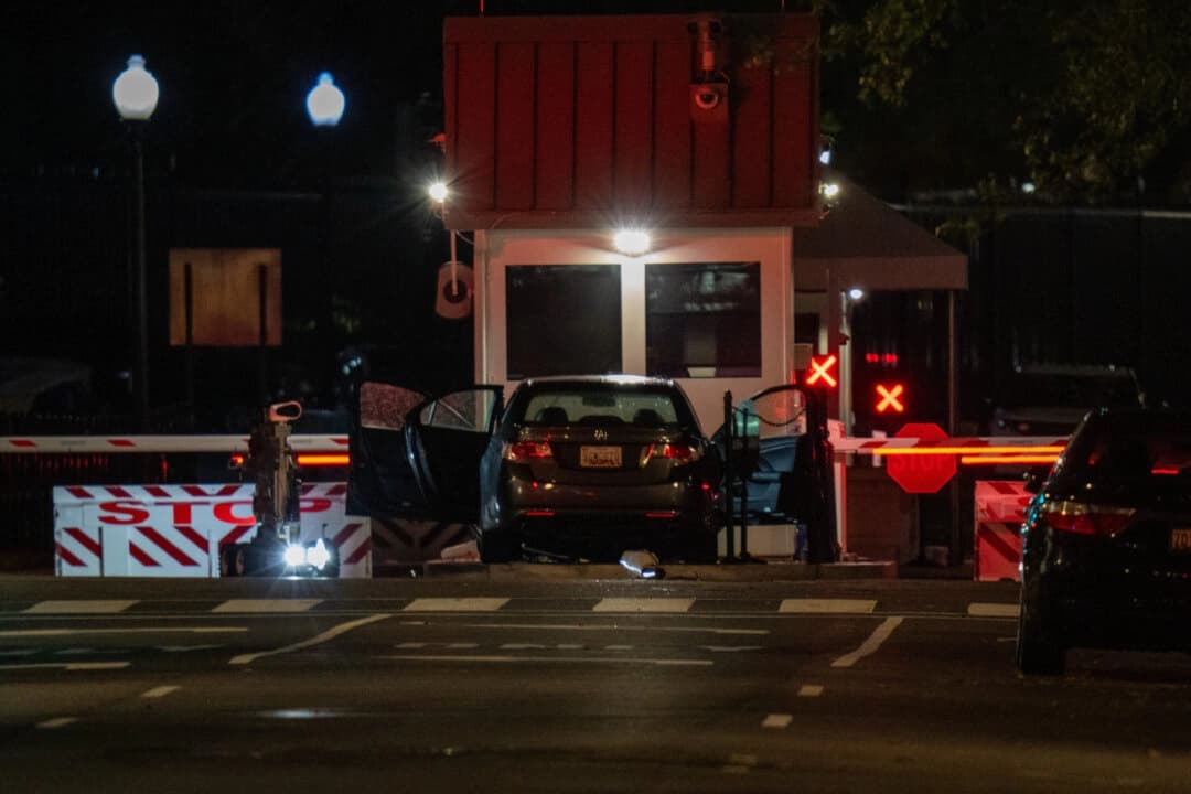 Un robot detector de bombas inspecciona un vehículo que embistió una barrera de seguridad en el complejo de la Casa Blanca el 21 de octubre de 2025. (Andrew Leyden/Getty Images)