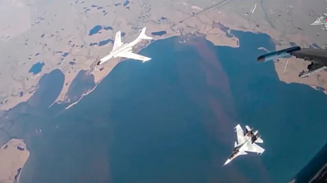 En esta foto tomada de un video publicado por el Servicio de Prensa del Ministerio de Defensa ruso el 25 de julio de 2024, se ve un bombardero de largo alcance H-6K de la fuerza aérea china, arriba a la izquierda, escoltado por un caza Su-30 de la fuerza aérea rusa durante una patrulla aérea conjunta entre Rusia y China. (Servicio de Prensa del Ministerio de Defensa ruso a través de AP).