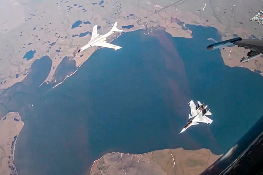 En esta foto tomada de un video publicado por el Servicio de Prensa del Ministerio de Defensa ruso el 25 de julio de 2024, se ve un bombardero de largo alcance H-6K de la fuerza aérea china, arriba a la izquierda, escoltado por un caza Su-30 de la fuerza aérea rusa durante una patrulla aérea conjunta entre Rusia y China. (Servicio de Prensa del Ministerio de Defensa ruso a través de AP).