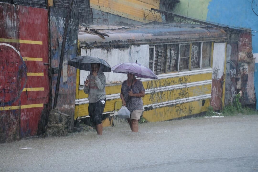La gente camina por una calle inundada por las lluvias causadas por la tormenta tropical Melissa en Santo Domingo, República Dominicana, el 24 de octubre de 2025. (Ricardo Hernández/AP Photo)