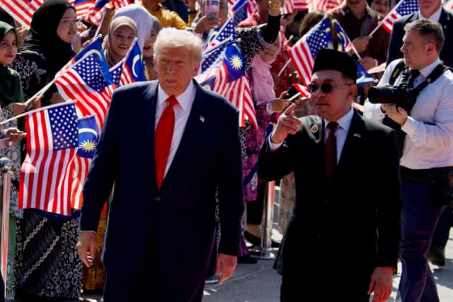 El presidente Donald Trump y el primer ministro de Malasia, Anwar Ibrahim, hablan en la pista del aeropuerto de Kuala Lumpur, el 26 de octubre de 2025. (Travis Gillmore/The Epoch Times)