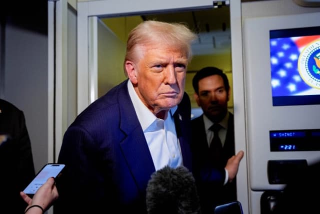 El presidente de Estados Unidos, Donald Trump, acompañado por el secretario de Estado Marco Rubio (derecha), responde a una pregunta de un periodista a bordo del Air Force One, el 27 de octubre de 2025. (Andrew Harnik/Getty Images)