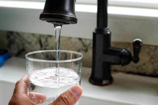 Una persona llena un vaso de agua del grifo en San Anselmo, California, el 6 de julio de 2023. (Justin Sullivan/Getty Images)