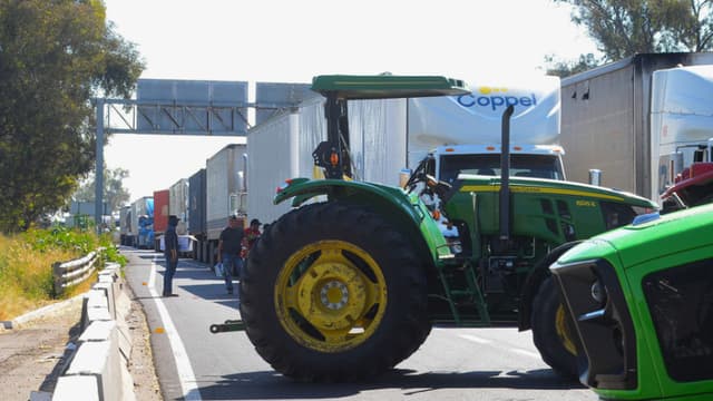 Tractores de agricultores bloquean la carretera que comunica de León a Aguascalientes este martes, en León, México. La presidenta de México, Claudia Sheinbaum, aseguró que su Gobierno mantiene abiertas las mesas de diálogo con los productores agrícolas que han protagonizado protestas en distintas regiones del país en exigencia de fijar el precio mínimo del maíz en 7200 pesos (unos 391 dólares). (EFE/ Luis Ramírez)