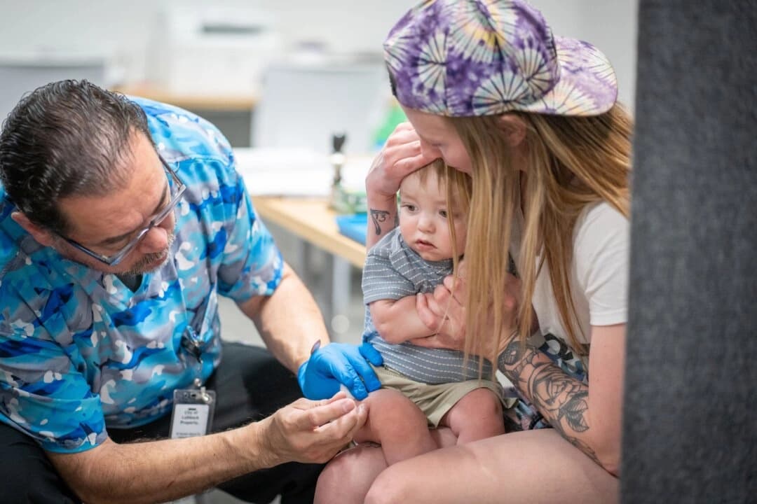 River Jacobs, de un año, es sostenido por su madre, Caitlin Fuller, mientras recibe la vacuna triple vírica en una clínica de Lubbock, Texas, el 1 de marzo de 2025. (Jan Sonnenmair/Getty Images)