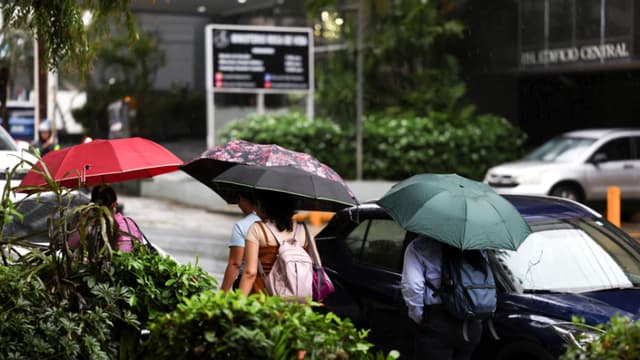 Un grupo de personas fue captado el pasado 27 de octubre al protegerse de la lluvia, en Ciudad de Panamá, donde se sintieron los efectos indirectos de paso del huracán Melissa por el Caribe. (EFE/Carlos Lemos)