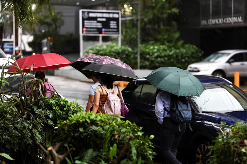 Un grupo de personas fue captado el pasado 27 de octubre al protegerse de la lluvia, en Ciudad de Panamá, donde se sintieron los efectos indirectos de paso del huracán Melissa por el Caribe. (EFE/Carlos Lemos)